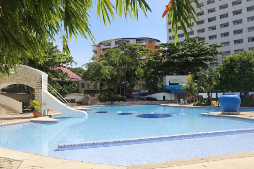 The dorm building sits right by the pool—just head downstairs for a swim