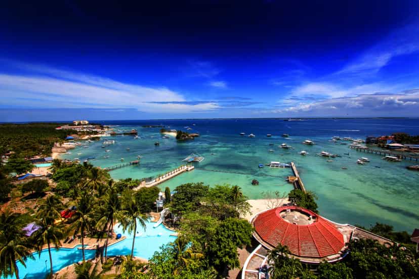 Pool, palm trees, and white sand beach all in one shot (vivid version)