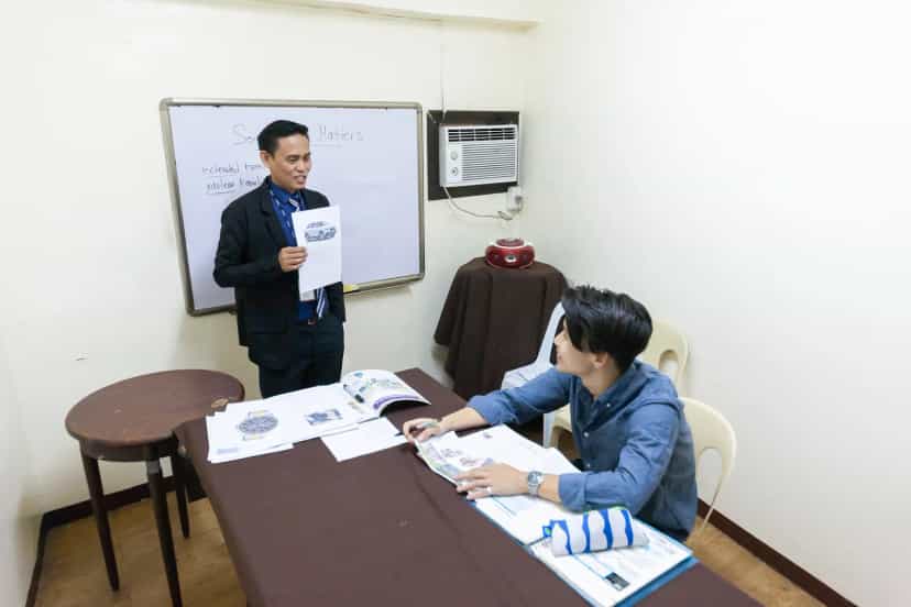 CPILS one-on-one English classroom, with a teacher using handouts to teach a student