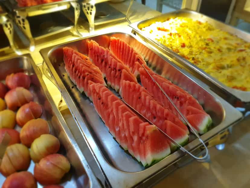 Watermelon, fruit, and hot dishes on the buffet counter in the CPILS student cafeteria