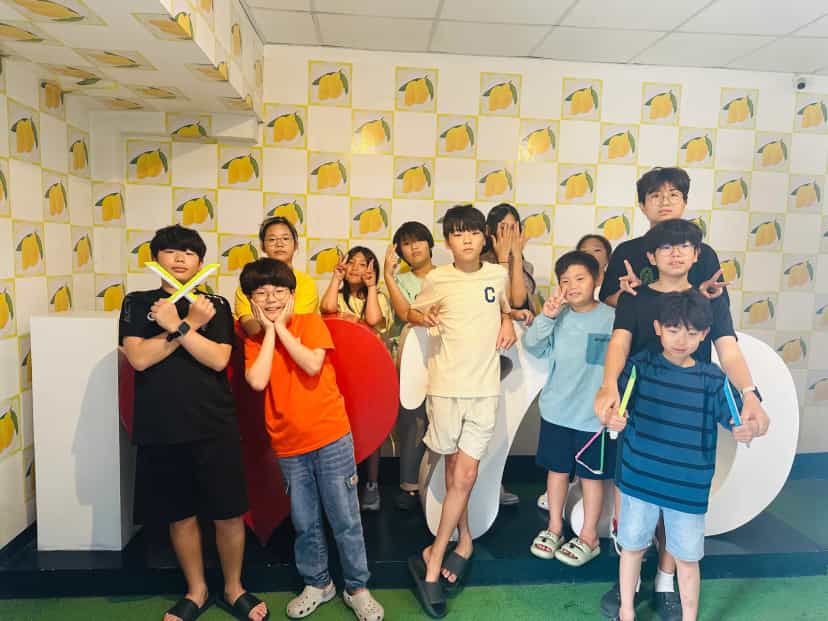 Students posing in front of the mango-themed wall at the 7D dried mango factory in Cebu