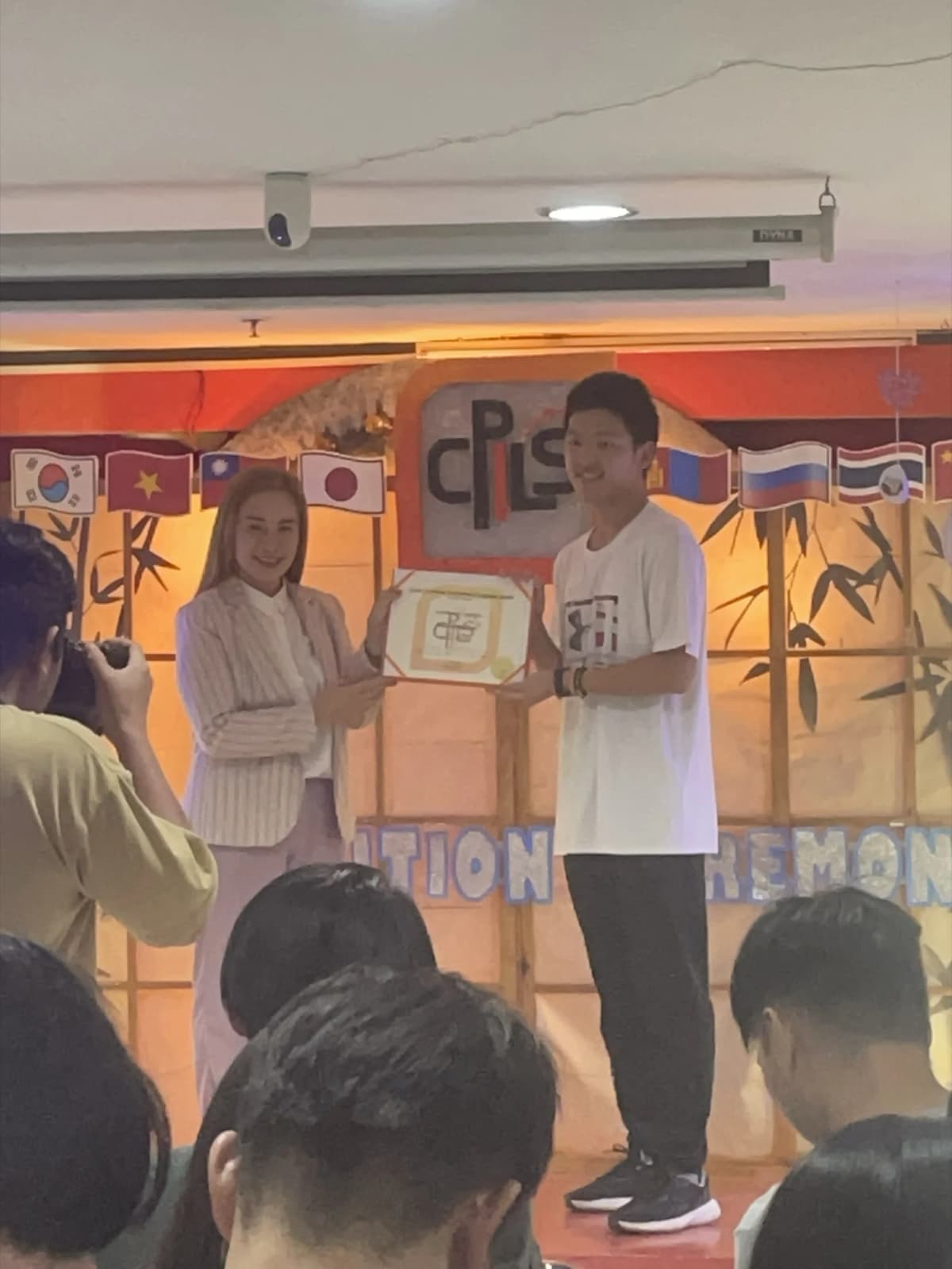 Anderson Tsai 在 CPILS 結業典禮舞台上領取證書,台下同學一同參與